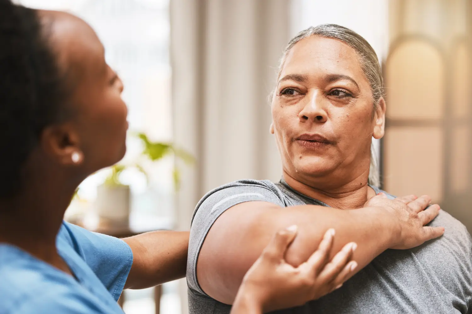 Physiotherapeutin, die Frauen in der Physiotherapie für Muskel-, Arthritis- oder Dehnungsübungen, Massage und Atemhilfe berät.